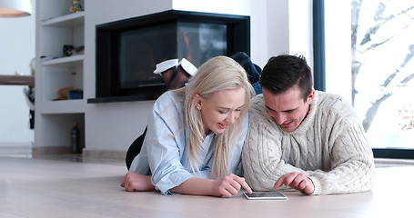 Image showing Young Couple using digital tablet on the floor