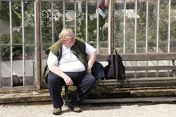 Image showing large man sitting on a bench