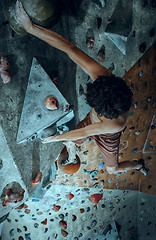 Image showing Free climber young man climbing artificial boulder indoors