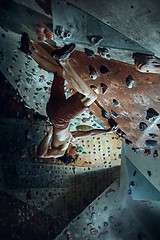 Image showing Free climber young man climbing artificial boulder indoors