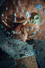 Image showing Free climber young man climbing artificial boulder indoors