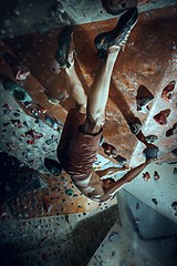 Image showing Free climber young man climbing artificial boulder indoors