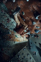 Image showing Free climber young man climbing artificial boulder indoors