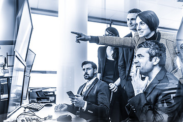 Image showing Successful business team looking at trade data on computer screens in corporate office.