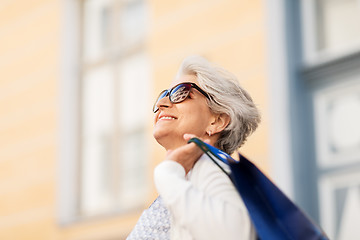 Image showing senior woman in sunglasses with shopping bags