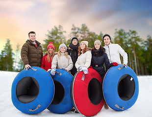 Image showing happy friends with snow tubes outdoors in winter