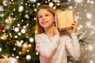 Image showing smiling girl with christmas gift at home