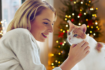 Image showing happy young woman with cat at home on christmas