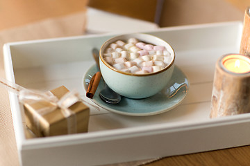 Image showing hot chocolate, christmas gift and candles on table