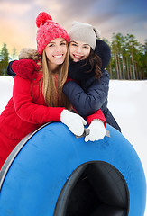 Image showing happy teenage girls with snow tubes in winter