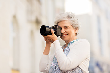 Image showing senior woman photographing by digital camera