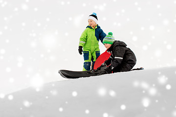 Image showing kids sliding on sleds down snow hill in winter