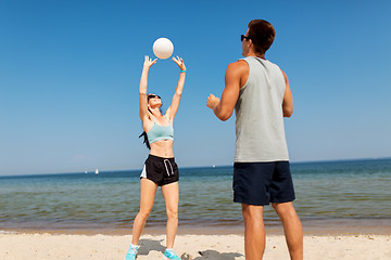 Image showing happy couple playing volleyball on summer beach