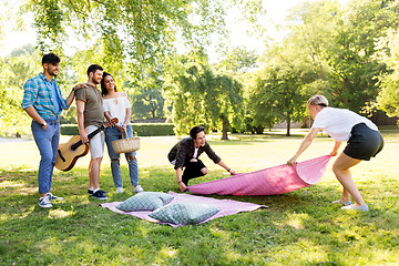 Image showing friends arranging place for picnic at summer park