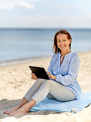 Image showing happy smiling woman with tablet pc on summer beach