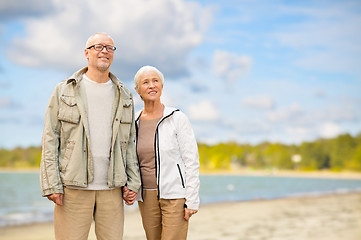Image showing happy senior couple over beach background