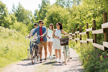 Image showing happy friends with fixed gear bicycles in summer