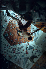 Image showing Free climber young man climbing artificial boulder indoors