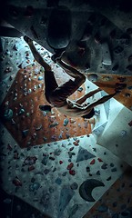 Image showing Free climber young man climbing artificial boulder indoors