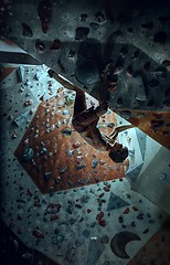 Image showing Free climber young man climbing artificial boulder indoors