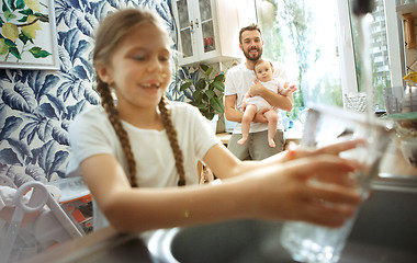 Image showing The happy smiling caucasian family in the kitchen preparing breakfast