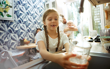 Image showing The happy smiling caucasian family in the kitchen preparing breakfast