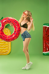 Image showing Cute girl in swimsuit posing at studio. Summer portrait caucasian teenager on green background.