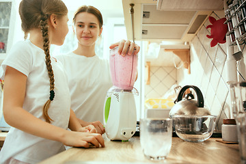 Image showing The happy smiling caucasian family in the kitchen preparing breakfast