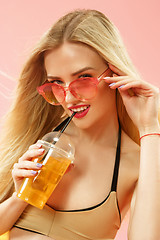 Image showing Cute girl in swimsuit posing at studio. Summer portrait caucasian teenagers on pink background.