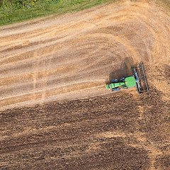 Image showing The tractor plows the field, preparing the soil for agricultural work. Top view.