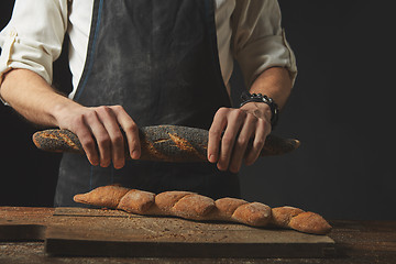 Image showing hands men break the baguette