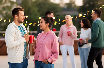 Image showing friends with drinks in party cups at rooftop