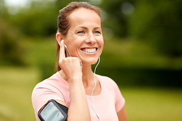 Image showing woman with earphones listening to music at park