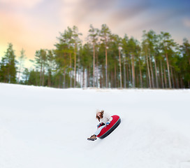 Image showing happy teenage girl sliding down hill on snow tube