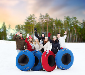 Image showing happy friends with snow tubes outdoors in winter