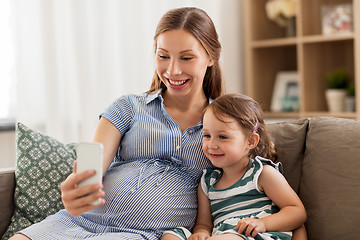 Image showing pregnant mother and daughter with smartphone