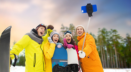 Image showing happy friends with snowboards and smartphone