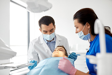 Image showing dentist checking for kid teeth at dental clinic
