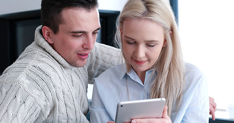 Image showing Young Couple using digital tablet on the floor