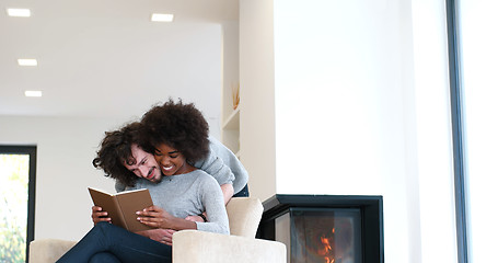 Image showing multiethnic couple hugging in front of fireplace