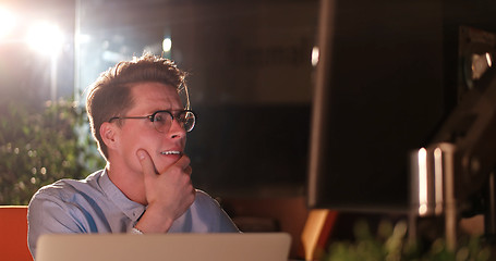 Image showing man working on computer in dark office