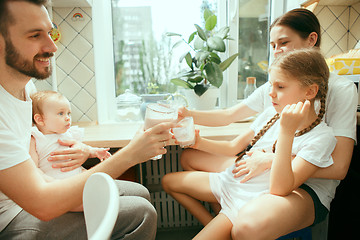 Image showing The happy smiling caucasian family in the kitchen preparing breakfast