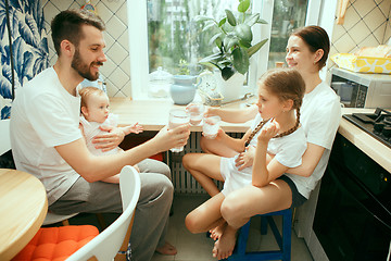 Image showing The happy smiling caucasian family in the kitchen preparing breakfast