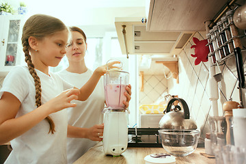 Image showing The happy smiling caucasian family in the kitchen preparing breakfast