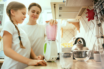 Image showing The happy smiling caucasian family in the kitchen preparing breakfast