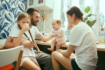 Image showing The happy smiling caucasian family in the kitchen preparing breakfast