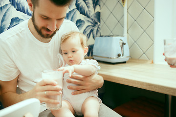 Image showing The happy smiling caucasian family in the kitchen preparing breakfast