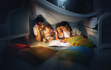 Image showing A small girl and grandmother reading book at home.