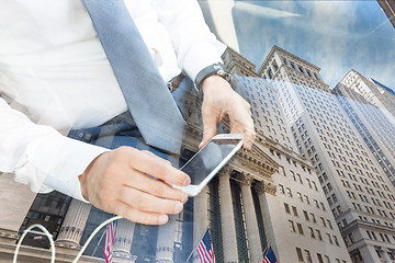 Image showing Close up of businessman using mobile smart phone in taxi against New York stock exchange reflection.