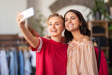 Image showing female friends taking selfie at clothing store